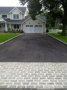 an empty driveway in front of a large house