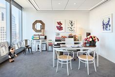 an office with white furniture and large windows