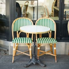 two chairs and a table in front of a store