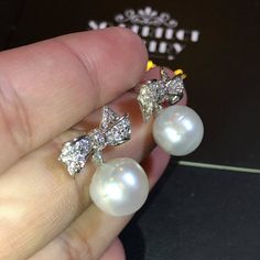 We are presenting you A PAIR OF matching SOUTH SEA PEARLS with LUSTROUS WHITE color. SET IN HANDCRAFTED, 18K SOLID GOLD DROP EARRINGS. ACCENTED WITH 64 E/VS, SPARKLING ROUND BRILLIANT DIAMONDS! IN CASE OF RETURN FOR US BUYERS. BUYERS MAY SEND THE ITEMS BACK TO OUR US-BASED OFFICE IN SALT LAKE CITY, UTAH ONLY ONE ITEM AVAILABLE!! NO DUPLICATES!! WHAT YOU SEE IN THE PICTURES IS WHAT YOU WILL GET SOLIDLY HANDCRAFTED EARRINGS! SUGGESTED RETAIL VALUE: $9,880 PEARLS: Size: 12 mm Shape: Oval/Round Colo White Cubic Zirconia Party Earrings, White Diamond Bridal Earrings For Party, White Diamond Bridal Earrings, White Pear-shaped Party Jewelry, Exquisite Diamond White Bridal Earrings For Party, Teardrop White Gold Bridal Earrings For Party, Elegant Diamond White Bridal Earrings For Celebrations, Sparkling White Earrings For Evening, Classic White Pearl Earrings For Party