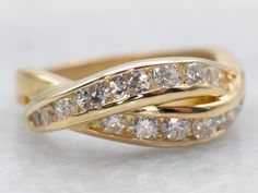 a yellow gold ring with white diamonds on it's sides and an intertwined band