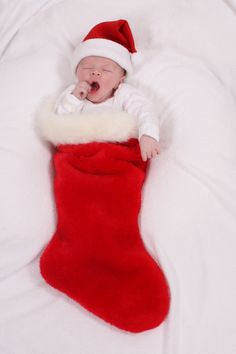 a baby is laying in a christmas stocking