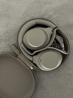 a set of headphones sitting in a case on the floor next to a plate