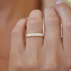 a woman's hand with a wedding band on it and a diamond ring in the middle