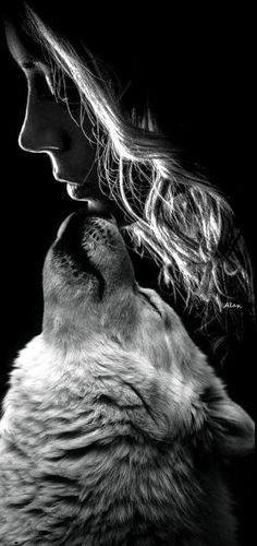 a black and white photo of a woman with her head in the air kissing a wolf