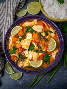 a purple bowl filled with chicken and vegetables next to rice, limes and cilantro