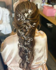 the back of a woman's head wearing a wedding hair comb with flowers in it