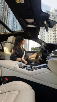 a woman sitting in the driver's seat of a car