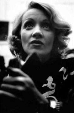 an old black and white photo of a woman holding a cell phone in her hand