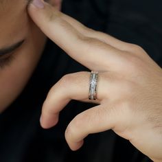 a close up of a person wearing a ring on their finger and touching his face