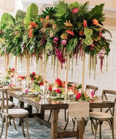 a long table with lots of flowers and greenery hanging from it's ceiling