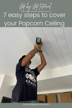 a man is painting the ceiling with white paint and he is using a power drill