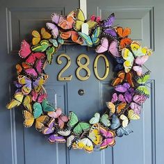 a wreath made out of butterflies with the number 208 on it's front door