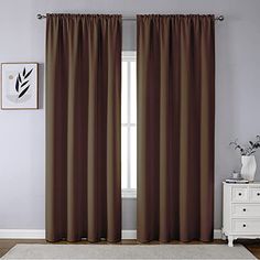 a living room with a white rug and brown curtains