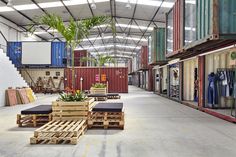 an empty warehouse filled with lots of storage containers and plants in it's center