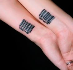 two people with barcode tattoos on their arms, both holding each other's hands