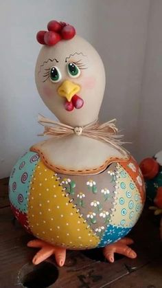 a ceramic chicken sitting on top of a wooden table