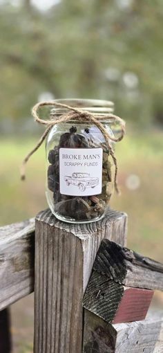 a jar filled with rocks sitting on top of a wooden fence