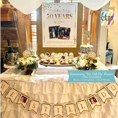 a table topped with cake and dessert covered in white frosting next to a sign that says celebrating 50 years of love