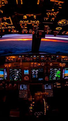 the cockpit of an airplane at night with illuminated lights and screens showing various aircraft's flight path