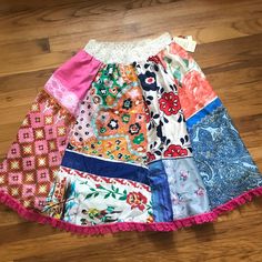 the colorful skirt is on the floor with many different colors and patterns, including pink, blue, green, red, white