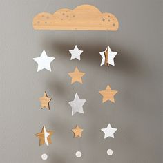 a wooden mobile with stars and clouds hanging from it's sides on a wall