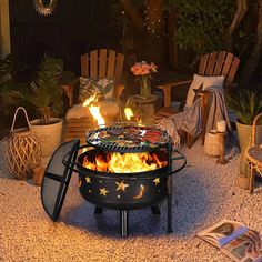 a fire pit sitting on top of a gravel ground next to chairs and potted plants