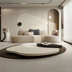 a modern living room with white furniture and black accents on the walls, along with a circular coffee table