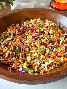 a wooden bowl filled with lots of different types of food on top of a table