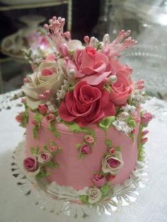 a pink cake decorated with flowers on top of a table