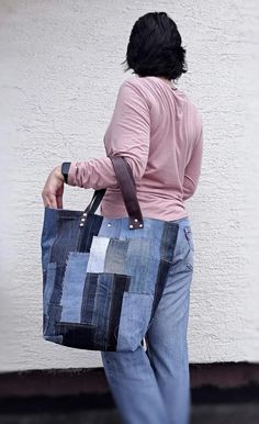 a woman carrying a blue patchwork tote bag on her left hand and back