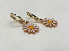 18K Gold-Filled Daisy Earrings Add a touch of playful elegance to your jewelry collection with these charming 18K gold-filled daisy earrings. Available in a huggie or ball post style, these earrings feature delicate daisy charms and add a cheerful summer vibe to any outfit. The secure huggie or ball post design ensures comfort and ease of wear, making them ideal for everyday use or special occasions. Cute Gold Flower Charm Earrings, Gold Daisy Earrings With Flower Charm, Gold Daisy Flower Earrings As Gift, Cute Gold Flower-shaped Earrings, Cute Gold Flower-shaped Jewelry, Hypoallergenic Yellow Gold Drop Flower Earrings, Cute Gold Huggie Earrings As Gift, Handmade Gold Daisy Earrings, Gold Dainty Flower Earrings