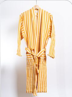 Add a touch of sunshine to your daily routine with the Girit Yellow Robe. This bright and cheerful robe, crafted from a soft cotton-linen blend, features bold yellow and white stripes, bringing a warm and vibrant feel to your mornings, spa sessions, or relaxation time. Perfect for lounging at home, by the pool, or as a stylish cover-up after a shower. The Girit Yellow Robe is designed for a comfortable and flattering fit. It is handwoven on semi-automated looms, showcasing traditional craftsmans