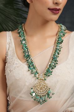 Green Kundan Inspired Necklace .This beautifully handcrafted necklace is set in silver and copper alloy and plated with 22k gold. This necklace with a twist of Pearl stones by Paisley Pop is a perfect accessory for an Indian Bride. Necklace Size - Length 36 inc, Width 1.5 inc Closure - Adjustable Thread Dori Style Tip - Wear this with almost anything Indian for a rich and royal look because nothing more regal than kundan necklace set. We love teaming this with classy chiffon sarees or zari silk Luxury Kundan Necklace With Zari Work For Designer Wear, Luxury Kundan Jewelry With Dangling Beads, Luxury Kundan Gemstone Necklace For Party, Luxury Green Kundan Necklace For Designer Wear, Luxury Fusion Style Kundan Necklace With Gemstone, Luxury Festive Kundan Necklace With Emerald, Luxury Spiritual Kundan Necklace With Gemstones, Luxury Green Fusion Kundan Necklace, Luxury Fusion Style Kundan Necklace For Party