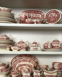 red and white china is displayed on shelves