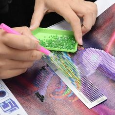 a person cutting beads with a pair of scissors