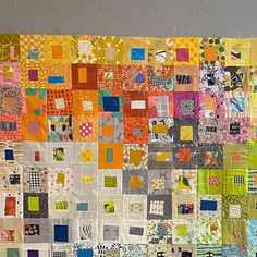 a large patchwork quilt hanging on the wall