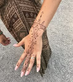 a woman's hand with henna tattoos on it