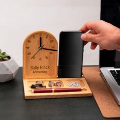 a person holding a cell phone next to a wooden clock