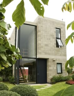 the house is made out of concrete and surrounded by greenery