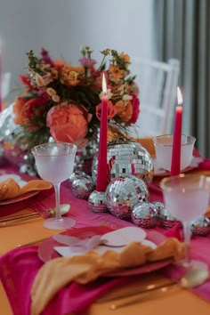 the table is set with silver and pink decorations