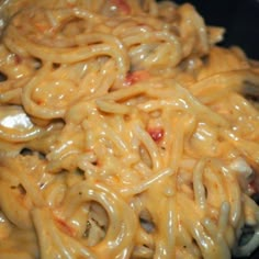 a black plate topped with pasta and sauce