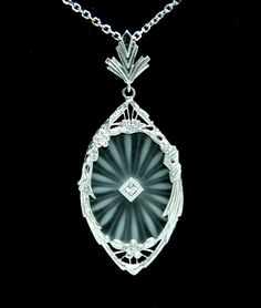 1950's Camphor Glass Diamond Filigree Pendant 50mm with 14K White Gold w/18" chain   Vintage, most likely 1950's filigree pendant with 18" chain (modern/contemporary chain was added for your convenience). We have replaced the pendant bail, the old one was worn-out. Pendant measures 50mm long and flanked with one natural diamond 0.03CT total weight (F-G in color, VS-SI1 in clarity, sparkly clean stone). Pendant set with camphor glass/crystal. All together pendant and chain weigh 7.2 grams. Chain, bail and pendant filigree frame made from 14K White Gold (bail stamped with 14K gold trademarks).     FREE SHIPPING IN THE US. NO INTERNATIONAL SHIPPING Camphor Glass Jewelry, 1920s Jewelry, Filigree Pendant Necklace, Vintage Jewlery, Quartz Crystal Necklace, Glass Jewellery, Filigree Pendant, Art Deco Diamond, Deco Jewelry