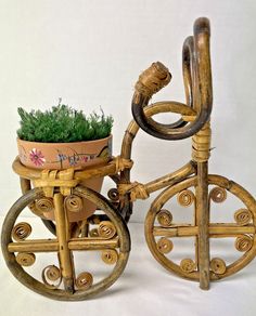 a wooden bike with a potted plant on the front and side wheel attached to it