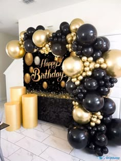 black and gold balloon arch with happy birthday sign