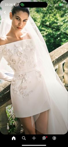 a woman in a wedding dress leaning on a railing with her hand on her hip