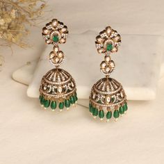 Description The Esther CZ Jhumka Earrings combine the classic and contemporary aesthetics seamlessly. They feature a distinctive design that draws inspiration from the Victorian era, embellished with sparkling CZ stones to enhance their allure. For an optimal effect, wear these exquisite earrings with your preferred Tarinika Jewelry pieces. Details & Specifications: Materials used: CZ Stone with Antique Gold Plating Weight - Earrings 31.35 gm Length - Earrings 7.5 cm Make it custom Want to make