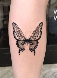 a black and white butterfly tattoo on the leg