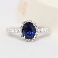 a blue sapphire and diamond ring on a white surface