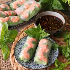 shrimp spring rolls on a plate with dipping sauce and lettuce in the background